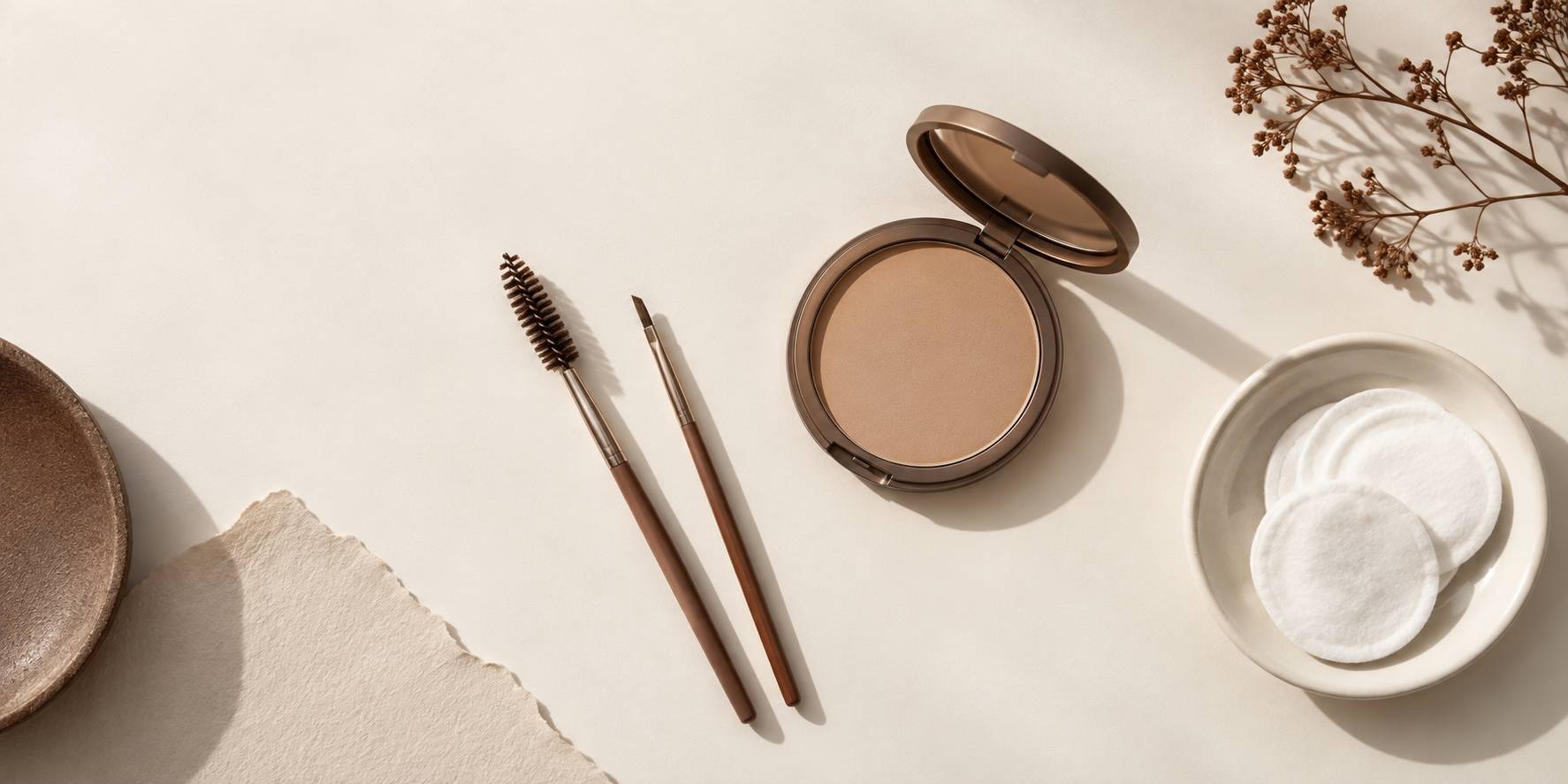 Brosse a sourcils et pinceau fin sur une table de maquillage minimaliste