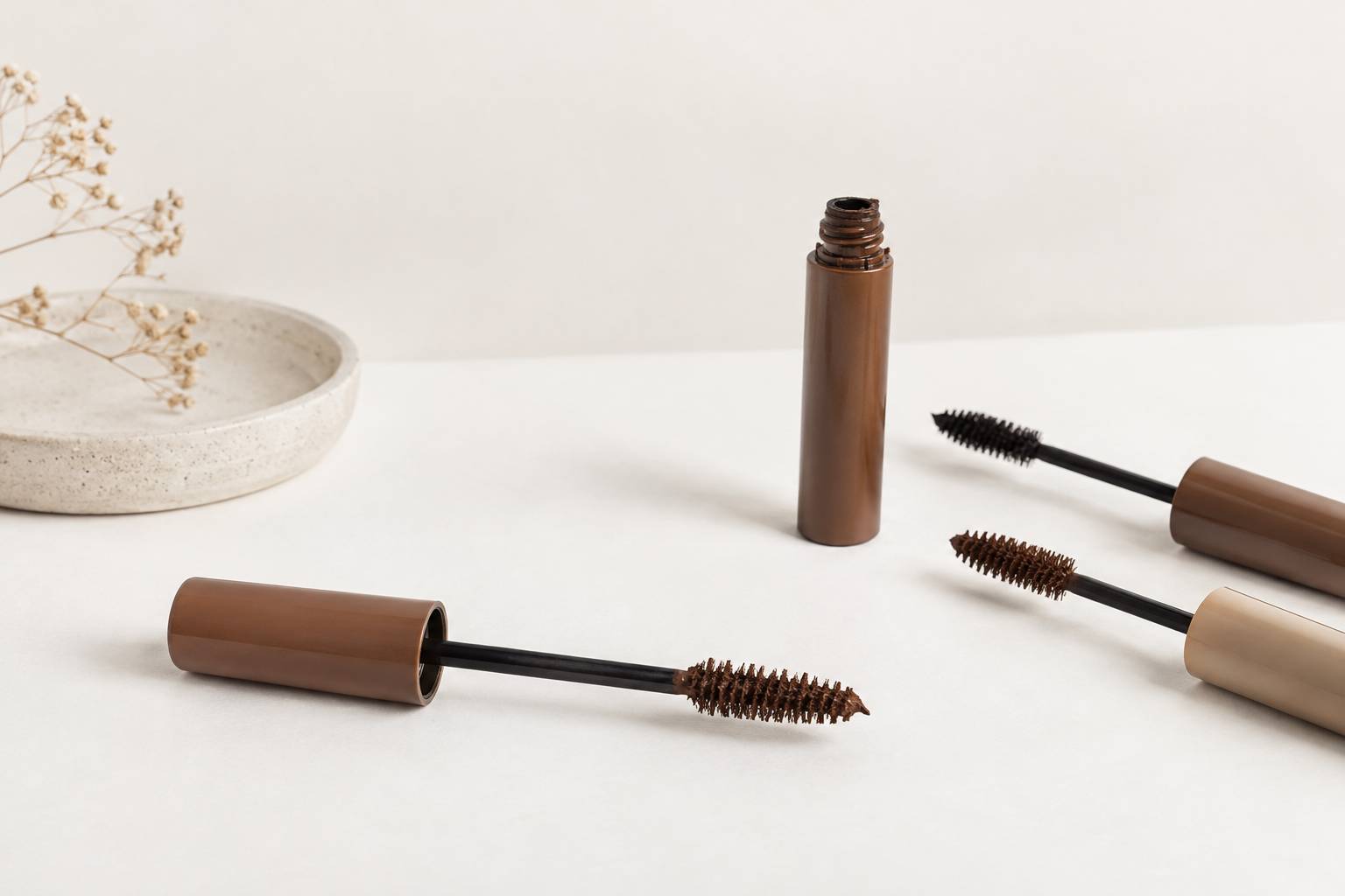 Brosse de mascara neutre en gros plan sur une surface claire